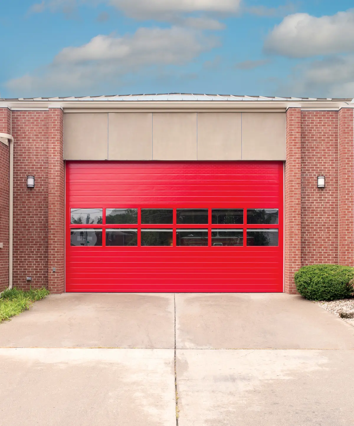 A red glass commercial overhead door in a brick building